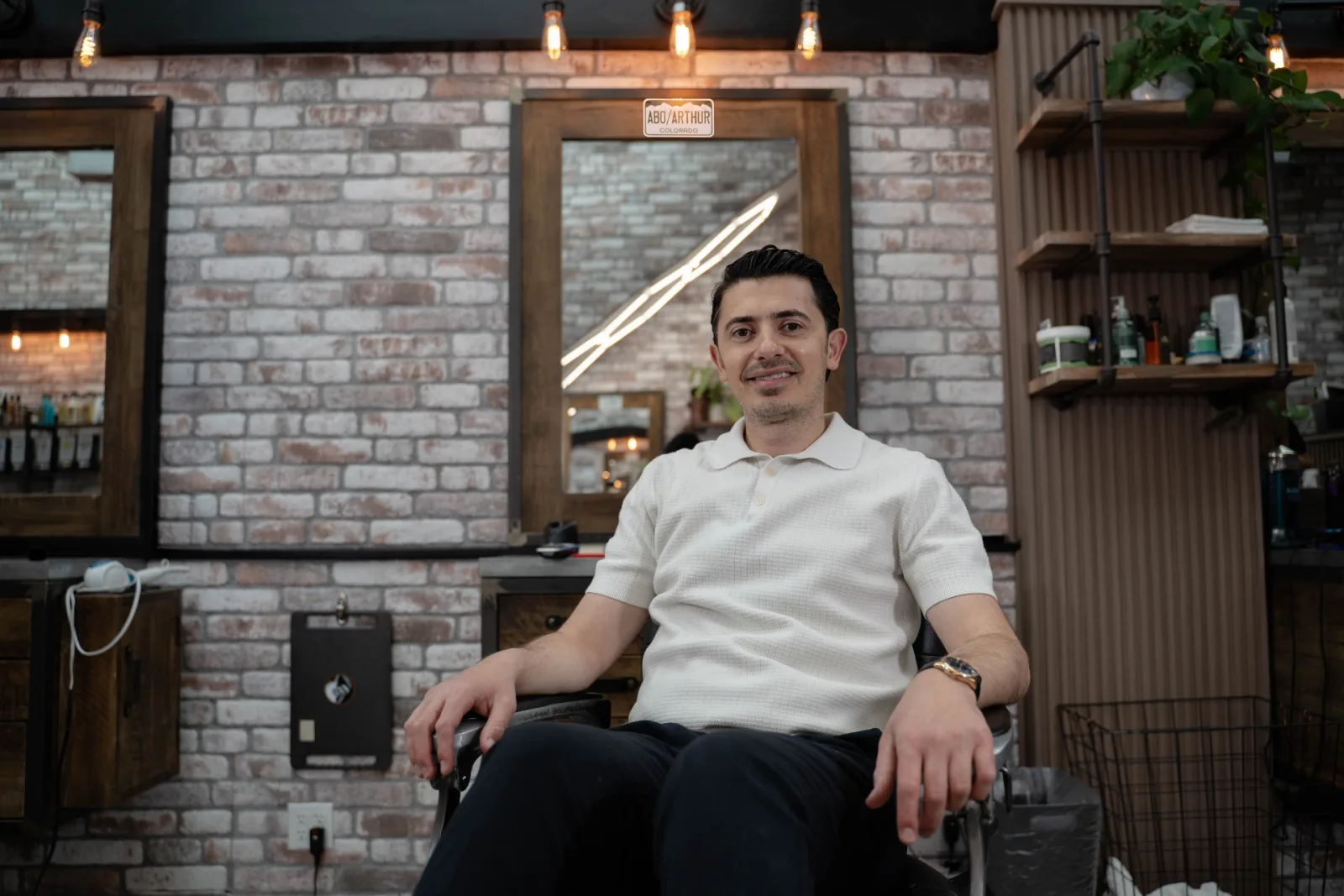 Artur 'Abo' Simonov, master barber and owner of Alfani's Barbershop on East Colfax Denver, seated in the barber chair