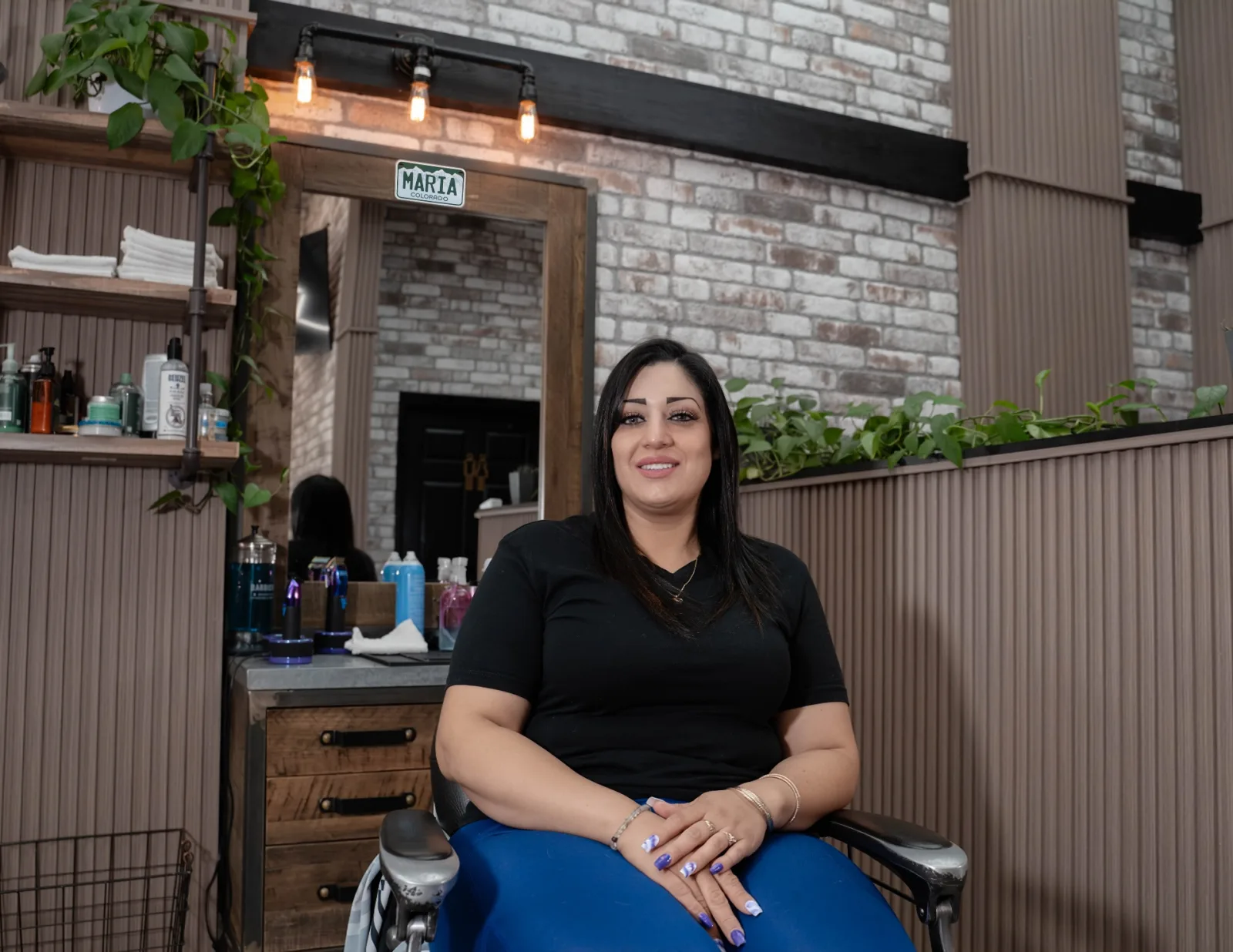 Maria, licensed barber and cosmetologist at Alfani's Barbershop Denver, at her station on East Colfax Avenue