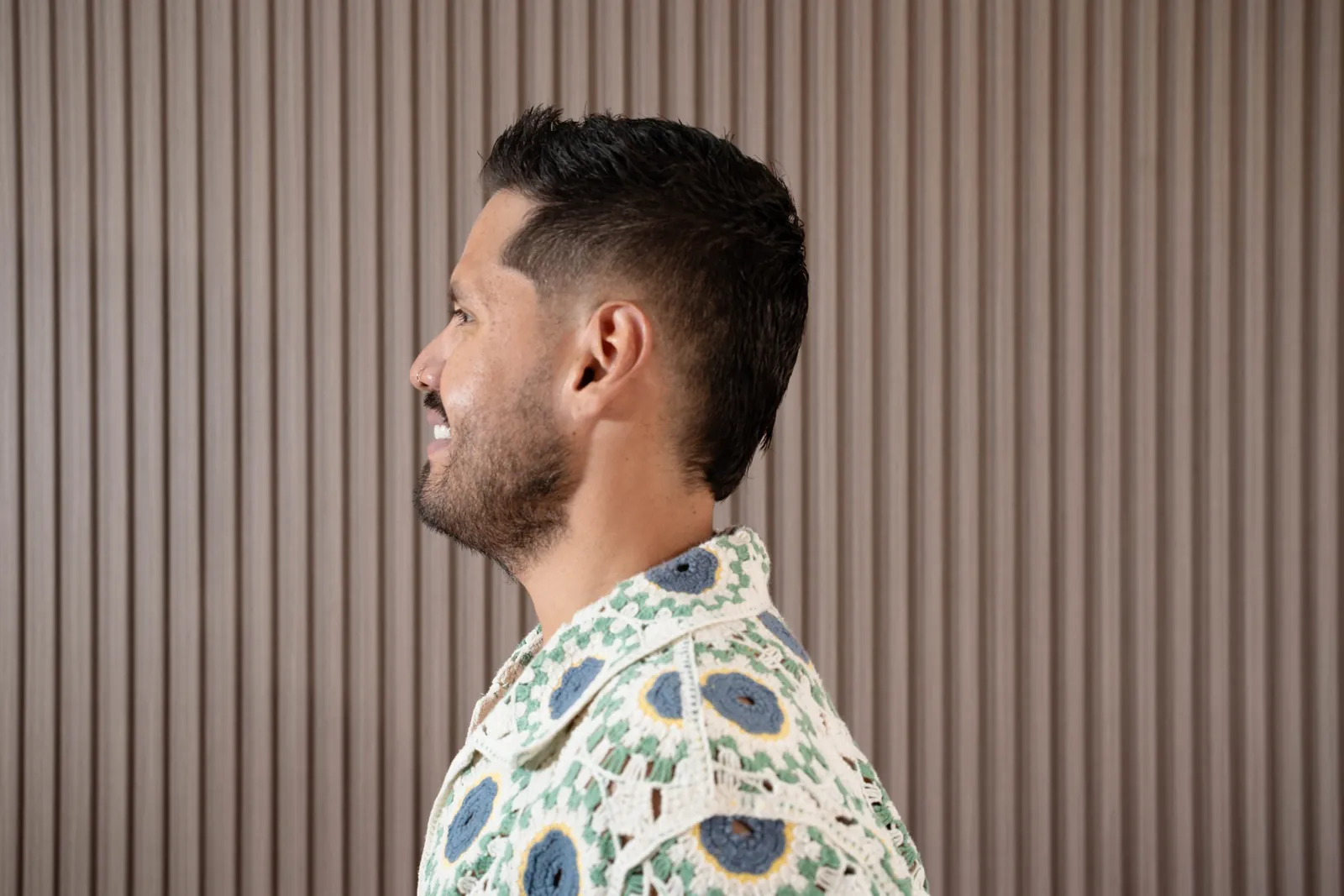 Lucca side profile working a razor-sharp fade at Alfani's Barbershop Denver