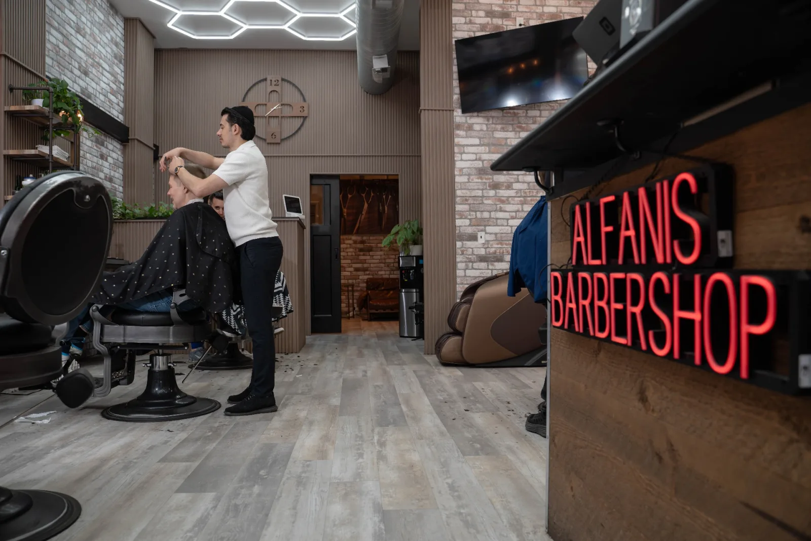 Abo cutting hair under the Alfani's neon sign on East Colfax Denver