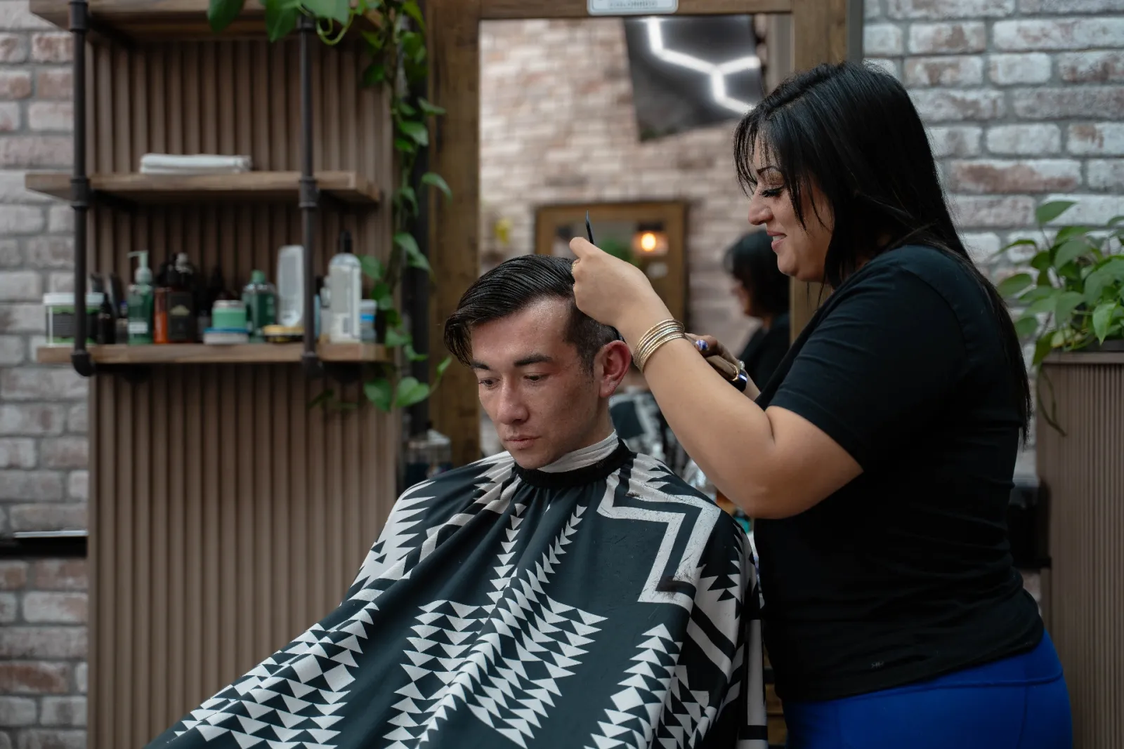Maria detailing a precision comb-over haircut at Alfani's Barbershop East Colfax Denver