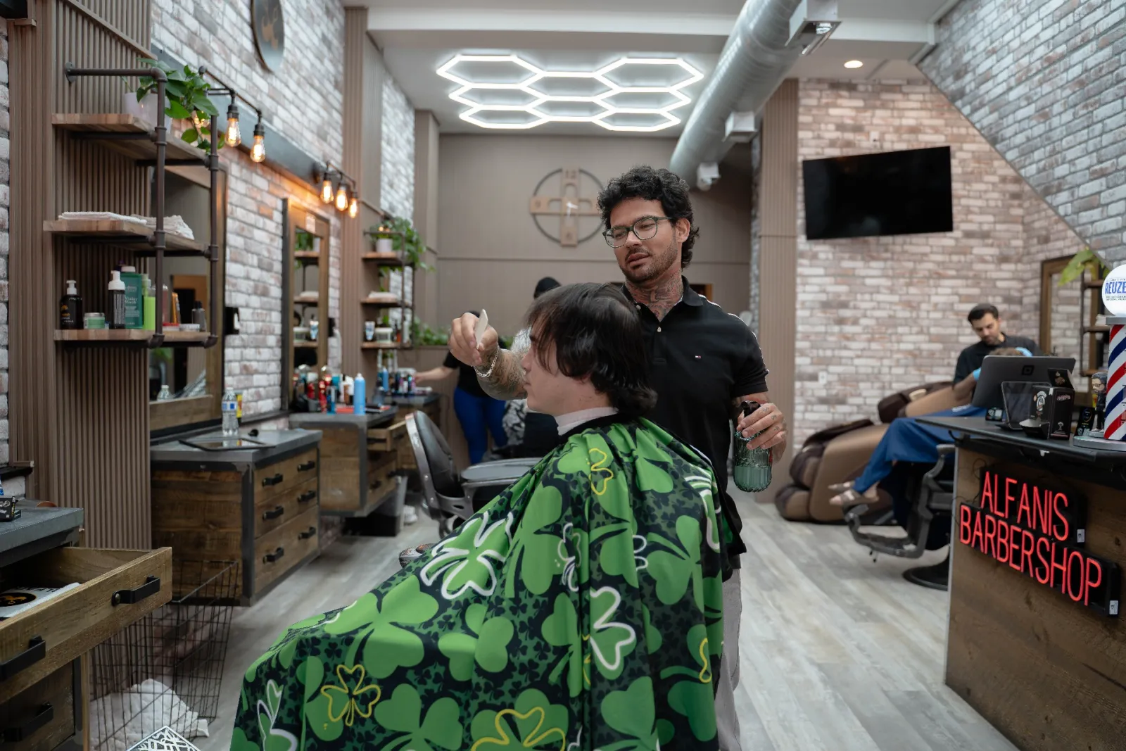 Lucca styling and spraying a finished haircut for a Denver client at Alfani's Barbershop