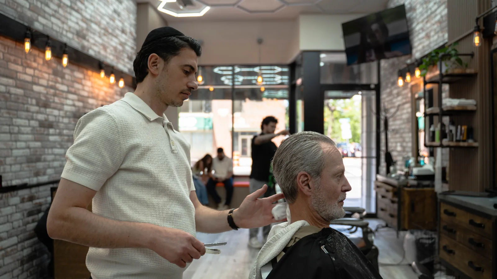 Abo finishing a straight razor lineup on a Denver client at Alfani's Barbershop